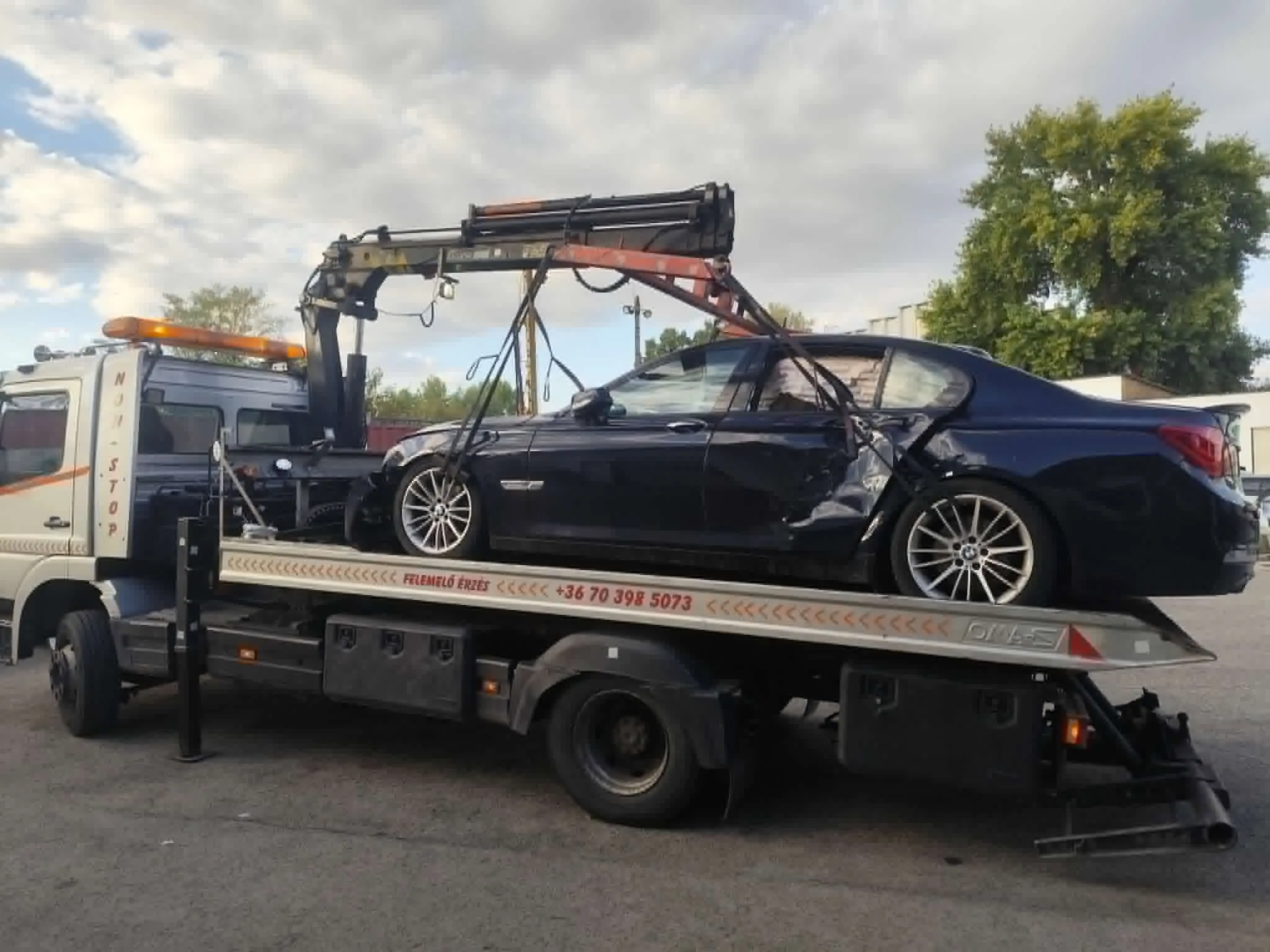 Sérült fekete BMW darus platós vontatón