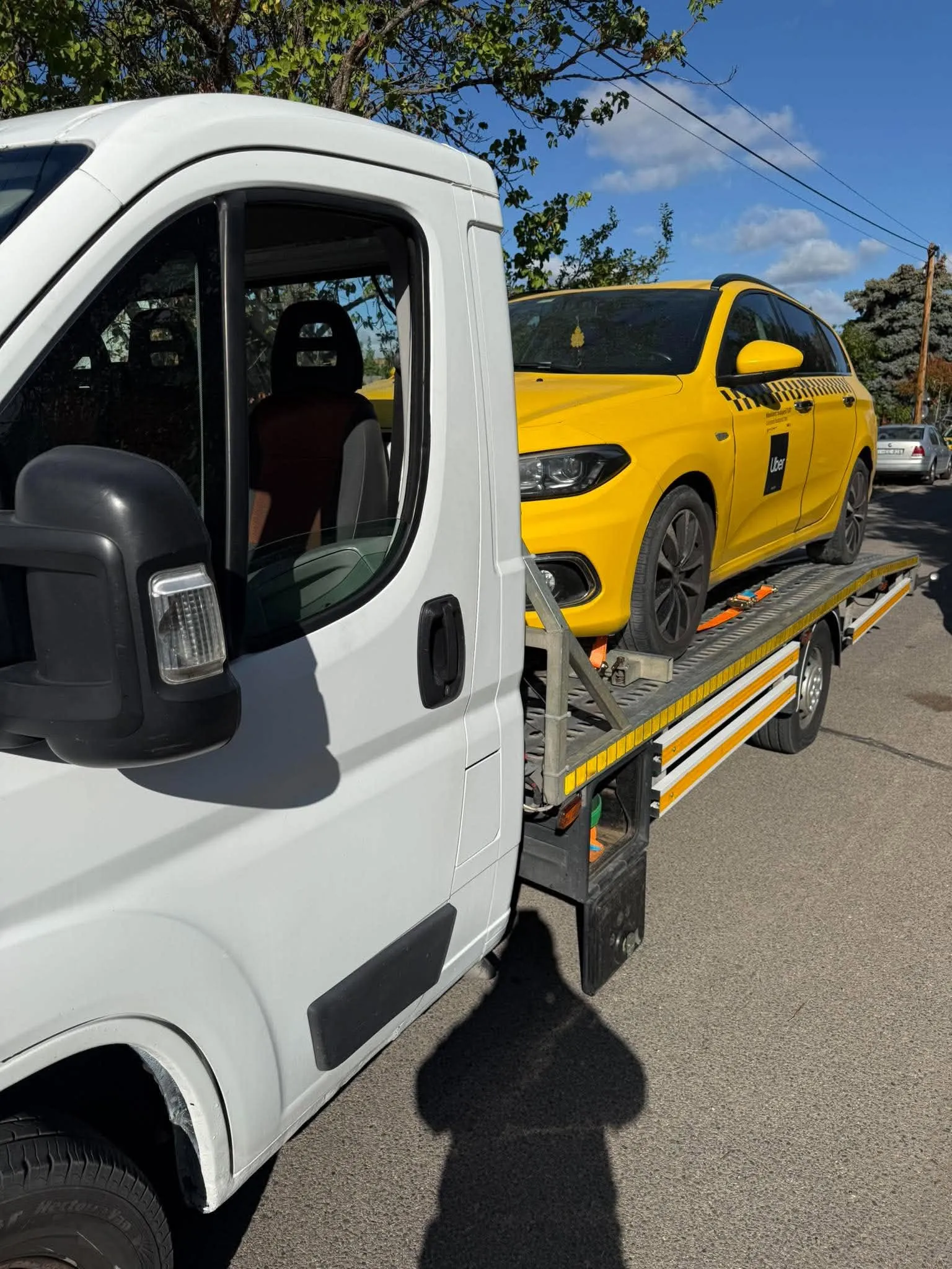 Sárga taxi szállítása platós vontatón