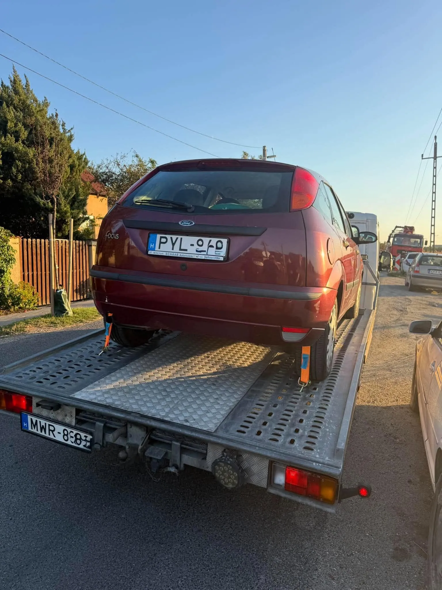 Piros autó a vontató platóján